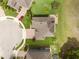 An aerial view showcases a well-maintained house with a lush green lawn, landscaping, and a brick-paved driveway and walkway at 32004 Redtail Reserve Blvd, Sorrento, FL 32776