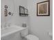 Stylish half bathroom with pedestal sink, decorative mirror and tasteful decor at 32004 Redtail Reserve Blvd, Sorrento, FL 32776