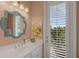 Bright bathroom featuring a vanity with double sink, stylish mirror, and door to the exterior at 32004 Redtail Reserve Blvd, Sorrento, FL 32776