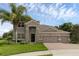 Beautiful exterior view of the home featuring a three-car garage, stone accents, and manicured lawn at 32004 Redtail Reserve Blvd, Sorrento, FL 32776