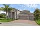 Attractive home features stone accents, a three-car garage, a brick driveway, and a well-manicured lawn at 32004 Redtail Reserve Blvd, Sorrento, FL 32776