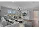 Bright living room with built-in shelving, a ceiling fan, and large windows overlooking the lawn at 32004 Redtail Reserve Blvd, Sorrento, FL 32776