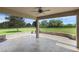 A covered patio features a stone surround, with a view of the large grassy yard beyond at 32004 Redtail Reserve Blvd, Sorrento, FL 32776