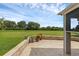 A covered patio features a stone surround, with a view of the large grassy yard beyond at 32004 Redtail Reserve Blvd, Sorrento, FL 32776