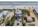 Breathtaking aerial view of a stunning beach home, surrounded by lush landscape and sandy shores at 3309 Hill St, New Smyrna Beach, FL 32169