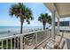 Relax on the balcony with stunning beach views and swaying palm trees, complete with comfortable seating at 3309 Hill St, New Smyrna Beach, FL 32169
