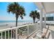 Relax on the balcony with stunning beach views and swaying palm trees, complete with comfortable seating at 3309 Hill St, New Smyrna Beach, FL 32169