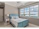 Inviting bedroom with a blue bed, ceiling fan, and scenic outdoor views at 3309 Hill St, New Smyrna Beach, FL 32169
