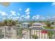 Scenic view from the home featuring palm trees and neighboring houses under a bright, cloudy sky at 3309 Hill St, New Smyrna Beach, FL 32169