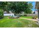 Grassy backyard featuring a fire pit area, stone walkway, and white storage shed at 415 Eastbridge Dr, Oviedo, FL 32765