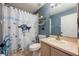 Bright bathroom features a fun shower curtain, toilet, sink vanity and shelving for storage and decor at 415 Eastbridge Dr, Oviedo, FL 32765