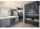 Well-lit bathroom with a double sink vanity, shower, and separate tub surrounded by dark tiling at 415 Eastbridge Dr, Oviedo, FL 32765