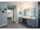 Bathroom with tile flooring, a double sink vanity, and a view into an adjacent bedroom at 415 Eastbridge Dr, Oviedo, FL 32765