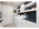 Well-organized laundry room with modern washer, dryer, stylish tile flooring and shelving for storage and decor at 415 Eastbridge Dr, Oviedo, FL 32765