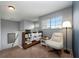 Comfortable loft space featuring a cozy chair, shelving with decor, a large window, and natural light at 415 Eastbridge Dr, Oviedo, FL 32765