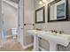 Bathroom featuring double pedestal sinks, decorative mirrors, and tile flooring at 419 Whitcomb Dr, Geneva, FL 32732
