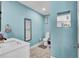 Fresh bathroom featuring blue paint, a modern vanity, a framed mirror and tile flooring at 443 Magpie Ct, Poinciana, FL 34759