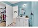 Bathroom showcasing vanity, mirror, lighting, and an open closet with abundant storage solutions at 443 Magpie Ct, Poinciana, FL 34759