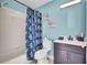 This bathroom features a vanity, a toilet, a shower and beautiful wall decorations at 443 Magpie Ct, Poinciana, FL 34759