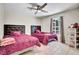This bedroom features two beds, tile floor, a ceiling fan, a window with curtains and a shoe rack at 443 Magpie Ct, Poinciana, FL 34759
