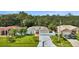 Exterior shot of home showcasing manicured lawn, shade trees, and long driveway at 443 Magpie Ct, Poinciana, FL 34759