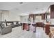 Open-concept kitchen featuring dark wood cabinets, stainless steel appliances, a center island, and modern bar stools at 443 Magpie Ct, Poinciana, FL 34759