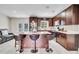 Open-concept kitchen featuring dark wood cabinets, stainless steel appliances, a center island, and modern bar stools at 443 Magpie Ct, Poinciana, FL 34759
