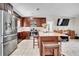 Stylish open-concept kitchen featuring dark wood cabinets, stainless steel appliances, and a center island at 443 Magpie Ct, Poinciana, FL 34759
