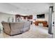 Spacious open-concept living room with dark wood cabinets, stainless steel appliances, and a grey leather sectional couch at 443 Magpie Ct, Poinciana, FL 34759