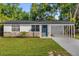 Charming home featuring stone accents, a blue front door, and a well-manicured lawn at 461 Brentwood Dr, Daytona Beach, FL 32117
