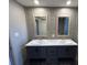 Bathroom with double sink vanity, framed mirrors, and gray tile backsplash at 4720 Oak St, Fruitland Park, FL 34731