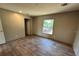 Bedroom with wood-look floors, a window, and a door leading to another room at 4720 Oak St, Fruitland Park, FL 34731