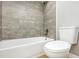Bathroom featuring tiled shower with gray tiling, modern fixtures, and a clean, white toilet at 520 Eagle Cir, Casselberry, FL 32707
