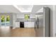 Modern kitchen features white cabinets, granite countertops, stainless steel appliances, and a light-filled skylight above at 520 Eagle Cir, Casselberry, FL 32707