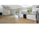 Open-concept living area flows to a kitchen featuring white cabinets, stainless steel appliances, and a sliding glass door at 520 Eagle Cir, Casselberry, FL 32707