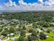 Panoramic aerial view showcasing a residential neighborhood near a large lake, surrounded by lush greenery and blue skies at 525 Garden Heights Dr, Winter Garden, FL 34787