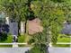 Aerial view of a single-story home with a brown roof nestled amongst mature trees in a well-maintained neighborhood at 525 Garden Heights Dr, Winter Garden, FL 34787