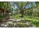 Lush backyard with a mix of trees, shrubs, and grass, ideal for outdoor activities at 525 Garden Heights Dr, Winter Garden, FL 34787