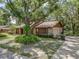 Charming single-story home with stone accents, mature trees, landscaping, and a long driveway leading to the attached garage at 525 Garden Heights Dr, Winter Garden, FL 34787