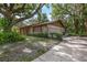 Charming single-story home with a stone facade and a two-car garage, surrounded by mature trees and lush landscaping at 525 Garden Heights Dr, Winter Garden, FL 34787