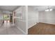 Bright hallway with tile flooring leading to a dining area with wood floors and wainscoting at 525 Garden Heights Dr, Winter Garden, FL 34787