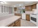 Open kitchen with wood cabinets, tile floors, and white appliances at 525 Garden Heights Dr, Winter Garden, FL 34787