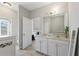 Bright bathroom with double sinks, tile flooring, and an open doorway to the main bedroom at 5368 Oakbourne Ave, Davenport, FL 33837