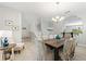 Bright dining area with a staircase, modern light fixture, and seamless transition into other living spaces at 5368 Oakbourne Ave, Davenport, FL 33837