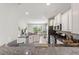 Open-concept kitchen with stone countertops, stainless steel appliances, and a view into the living area at 5368 Oakbourne Ave, Davenport, FL 33837