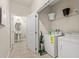 Bright laundry room features appliances, tile flooring, shelving, and access to the half bathroom at 5368 Oakbourne Ave, Davenport, FL 33837