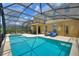 Relaxing screened-in pool area with lounge chairs and dining table for outdoor enjoyment and entertaining at 5368 Oakbourne Ave, Davenport, FL 33837