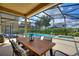 Relaxing screened-in patio area with dining table, lounge chairs, pool, and spa for outdoor enjoyment at 5368 Oakbourne Ave, Davenport, FL 33837