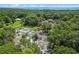 Aerial view of a rural property with tennis court, house and lush green space at 546 Winona Dr, Geneva, FL 32732