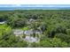 Aerial view of property featuring tennis court, home, lush greenery, mature trees, foliage and pond at 546 Winona Dr, Geneva, FL 32732